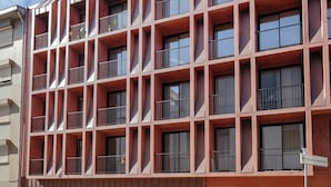 Un edificio de varios pisos con fachada de rejilla, balcones y un cartel que indica una clínica veterinaria hospitalaria.