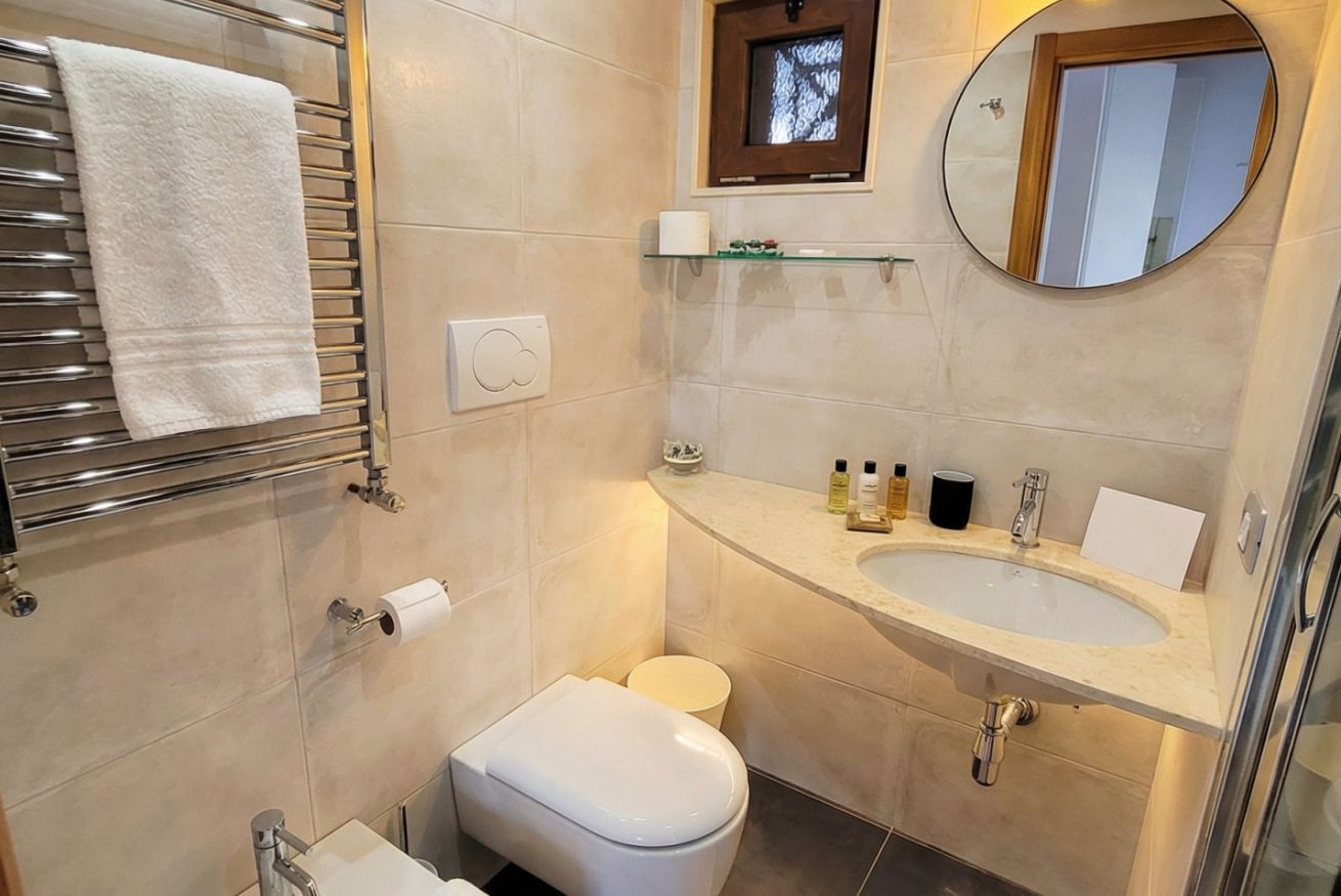 Un baño moderno con inodoro, lavamanos y toallero.