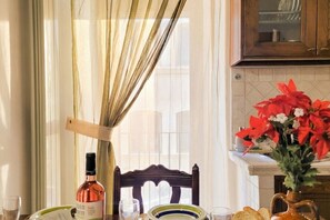 A dining table with a bottle of wine, glasses, and a plate.