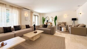 Un salon moderne avec un canapé d’angle, une table basse et un lampadaire.