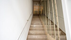 Un escalier doté d’une main courante et de rampes en verre, menant à l’étage supérieur.