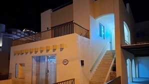 Un hotel de varios pisos con una escalera, una recepción y un balcón.