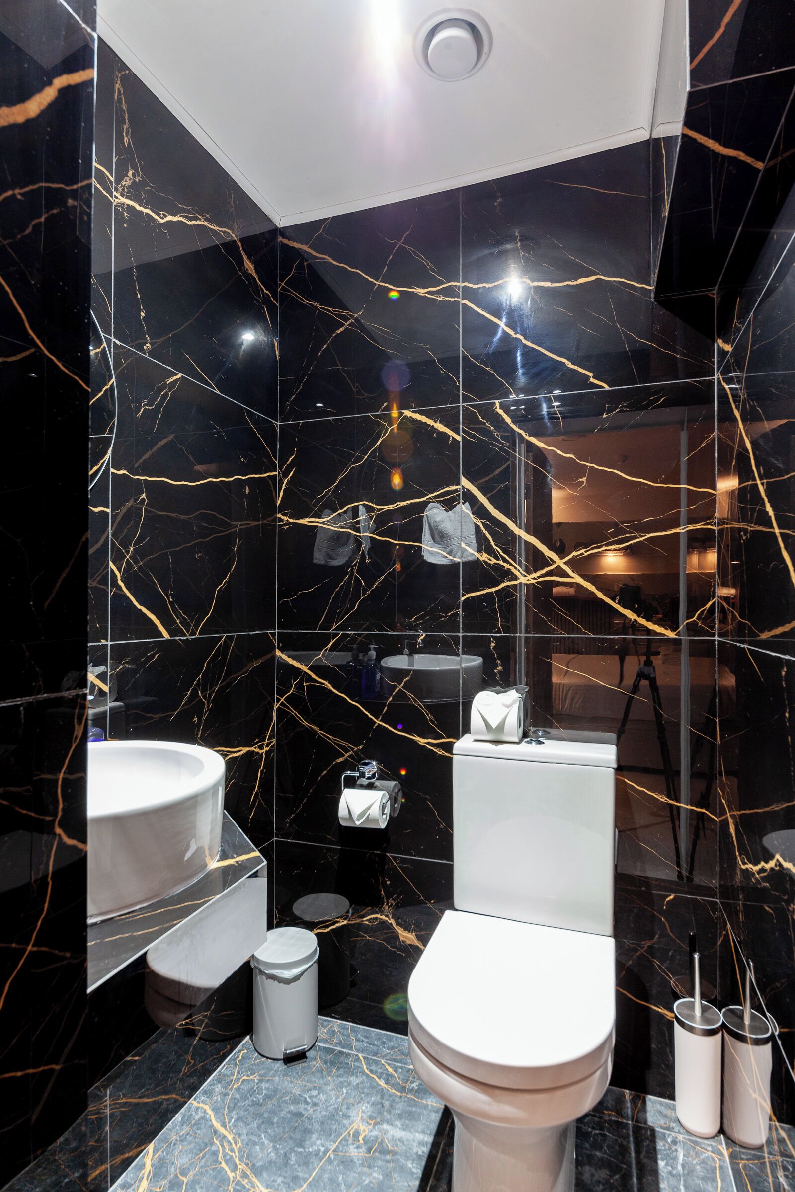A modern bathroom with a toilet, sink, and mirror.