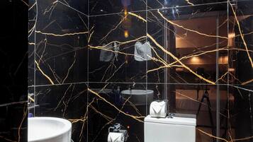 A modern bathroom with a toilet, sink, and mirror.