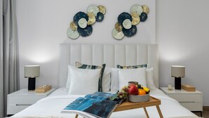 Ein modernes Schlafzimmer mit einem Bett, zwei Nachttischen, einer Nachttischlampe und Wandbildern.