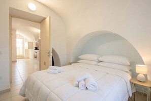 Une chambre d’hôtel avec un lit, une lampe et une vue sur le couloir.