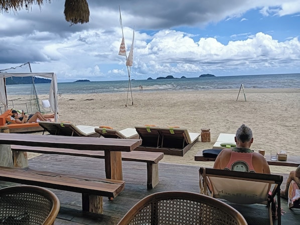 Pantai di sekitar, pasir putih, payung pantai, dan handuk pantai