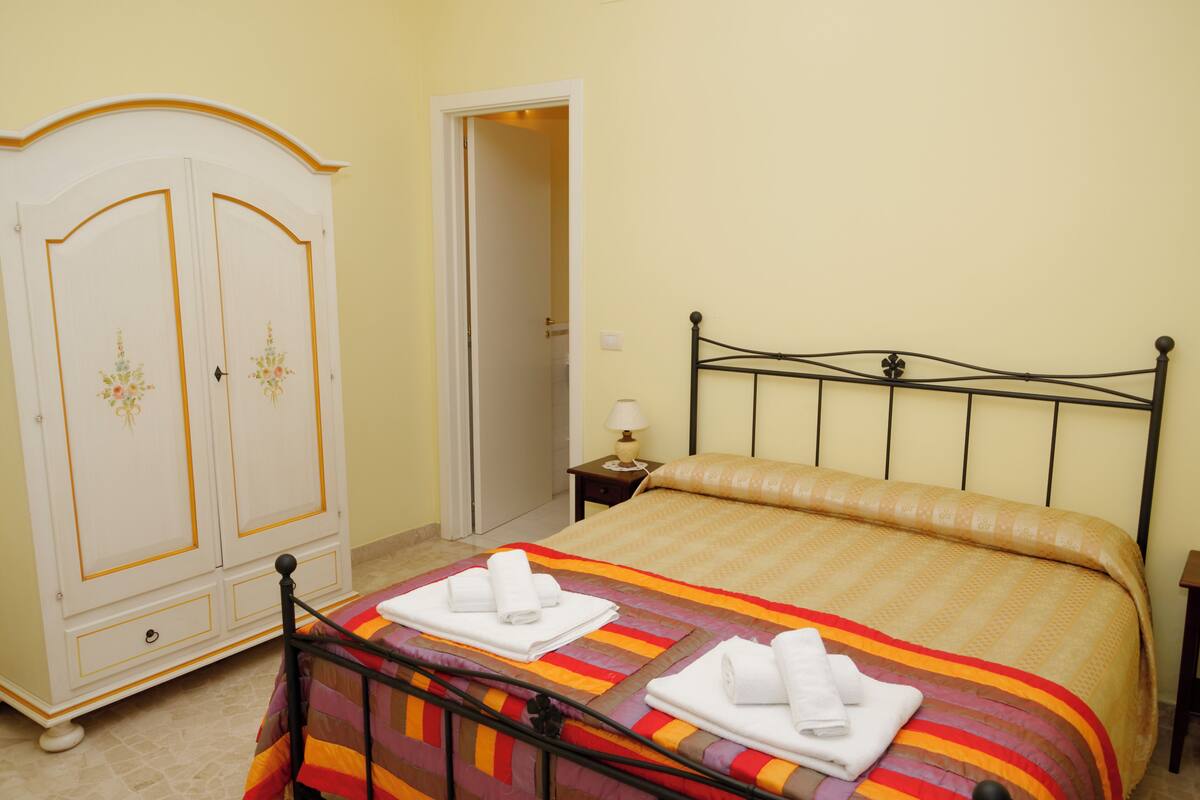Une chambre à coucher avec un lit, une armoire et une table de chevet.