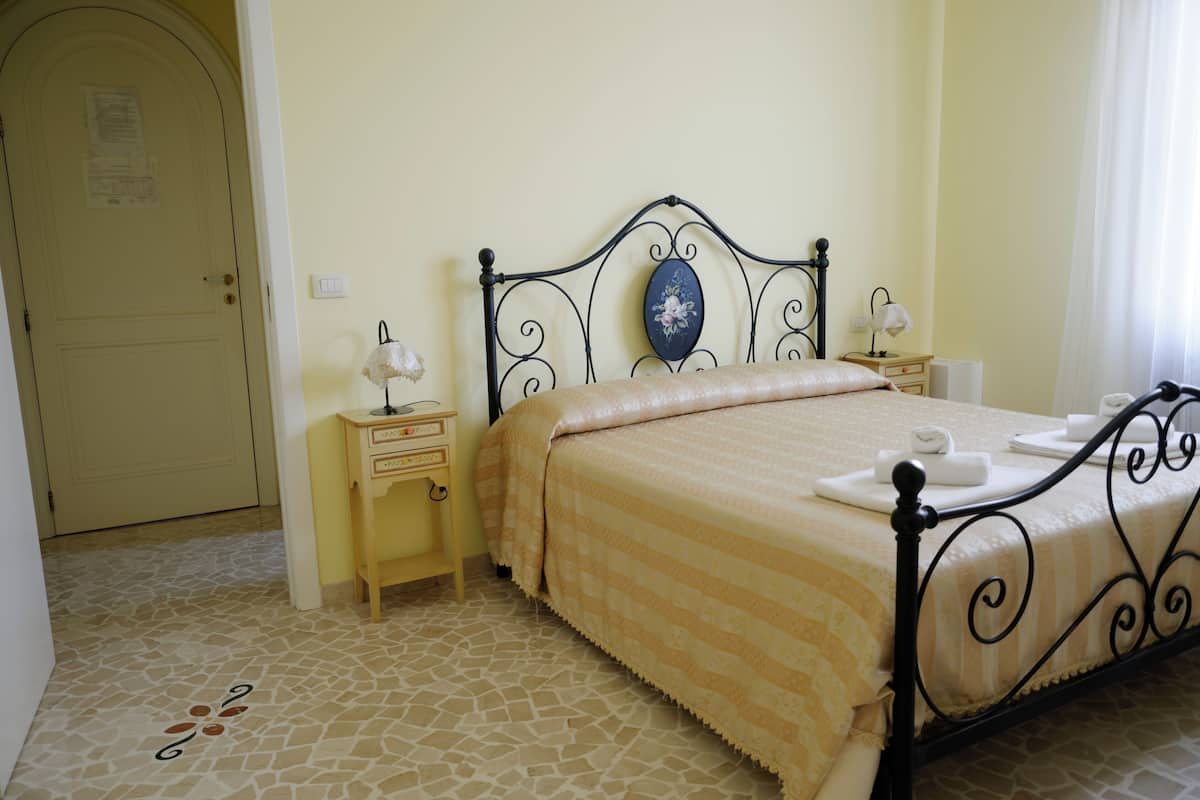 Une chambre bien rangée, avec un lit, des tables de chevet et une porte.