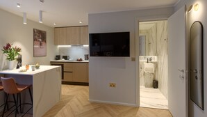Una cocina moderna con una isla central, armarios de madera y un televisor integrado.