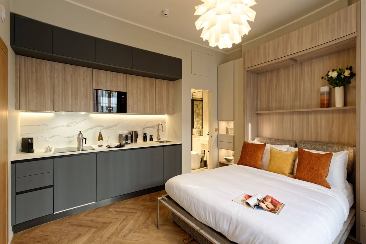 A modern bedroom with a large bed, bedside tables, and a built-in wardrobe.