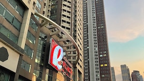 A high-rise building with a prominent Robinsons Place sign, surrounded by other tall buildings and a busy street with vehicles. - Modern Studio with Sunset View  (Manila)