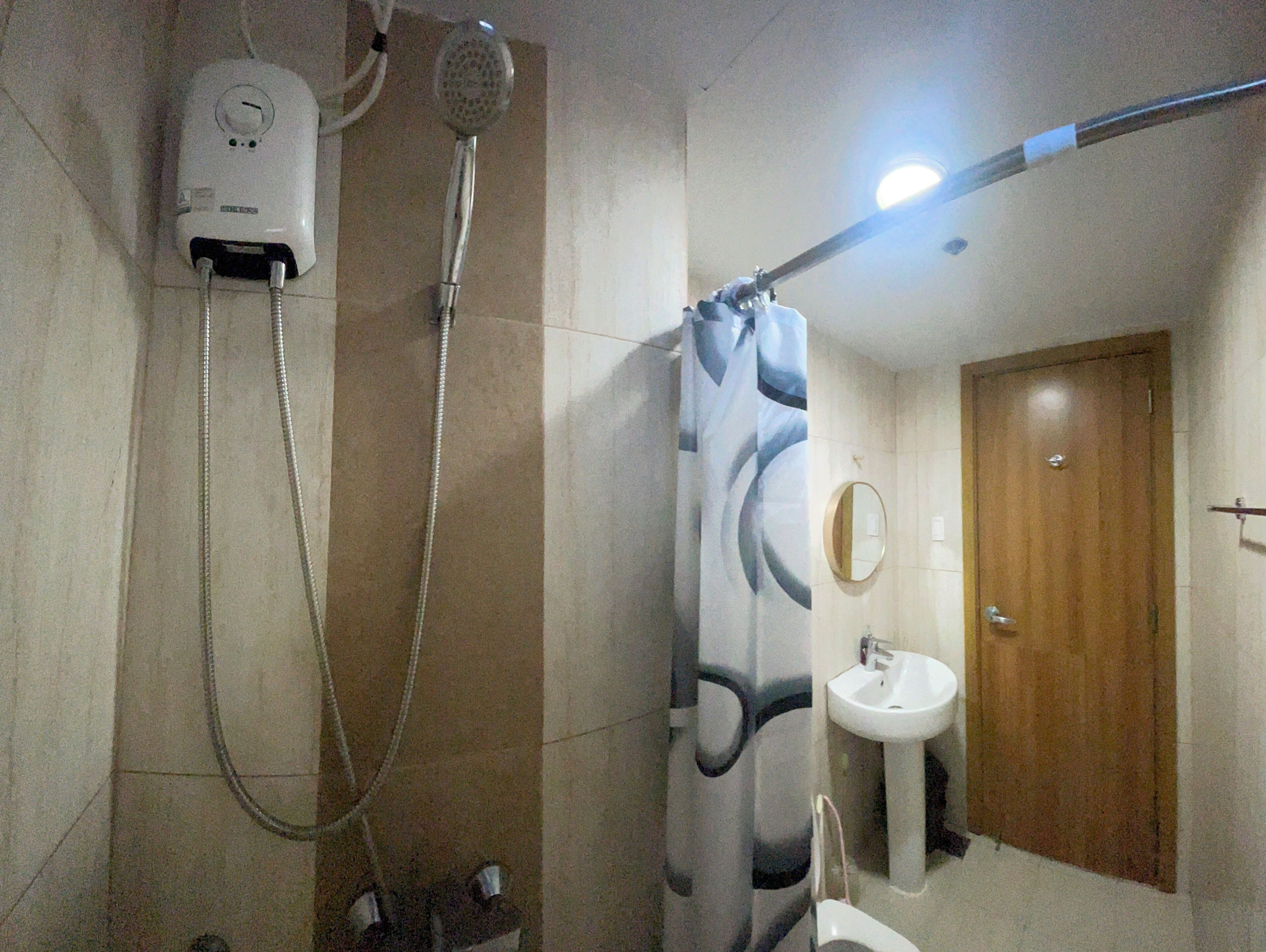 Ein Badezimmer mit Dusche, Waschbecken und Spiegel.