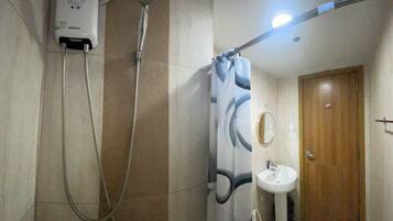 Ein Badezimmer mit Dusche, Waschbecken und Spiegel.