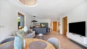 Una sala de estar moderna con sofá, mesa de comedor y televisor.