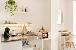 Une cuisine moderne équipée d’un four encastré, d’une machine à café et d’un évier.