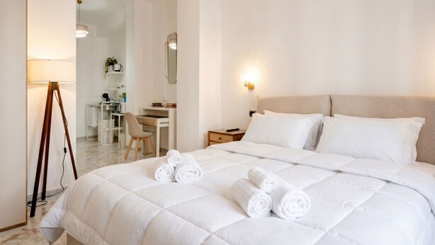 A hotel room with a bed, a desk, a chair, a lamp, and a mirror. - AuGuStea Urban Studio (Bari)