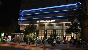 The exterior of the Al Jawar Hotel with illuminated signage and a modern architectural design. - Durrat Al Jawar (Makkah)