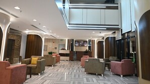 A spacious lobby with a high ceiling, modern lighting, and a reception desk. - Durrat Al Jawar (Makkah)