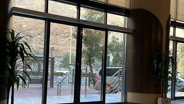 A spacious lobby with large windows, a polished floor, and a chandelier. - Durrat Al Jawar (Makkah)
