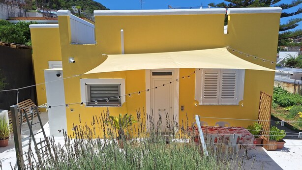 A yellow building with a white door, a small window, and a balcony. - La Campetella. Relaxation within walking distance of downtown. (Ischia)