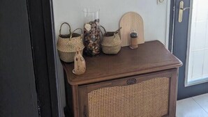 A wooden console table with woven baskets and a decorative item on a wall. - The Bangor Coon Apartment Liouba (Forges)