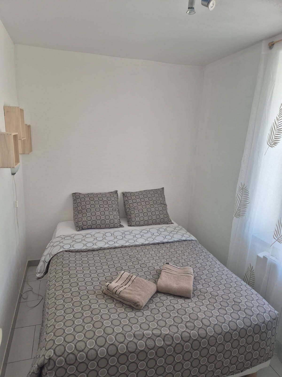 A bedroom with a bed, pillows, and towels.