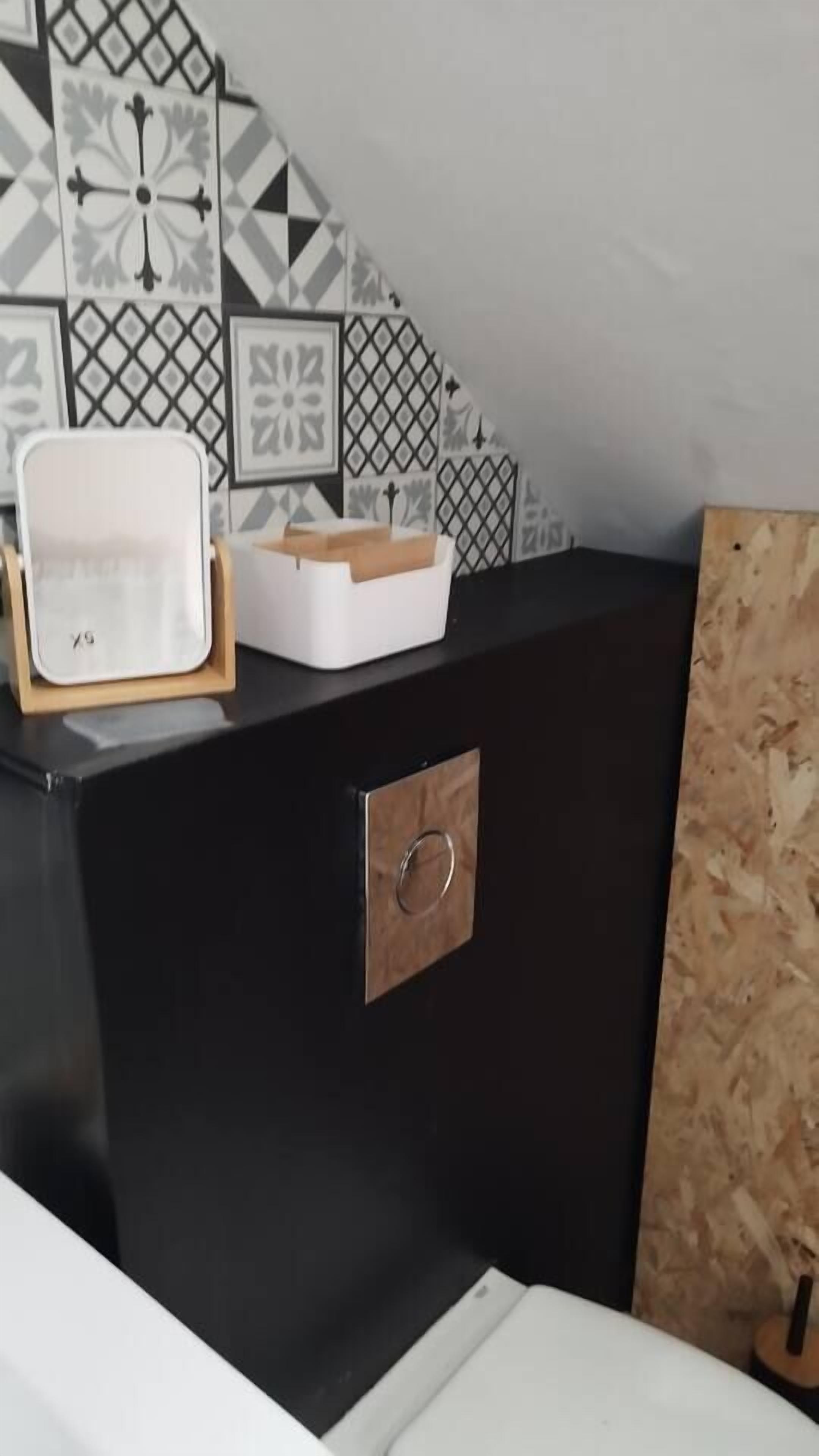Un comptoir noir sur lequel sont posés un plateau blanc et une boîte en bois.