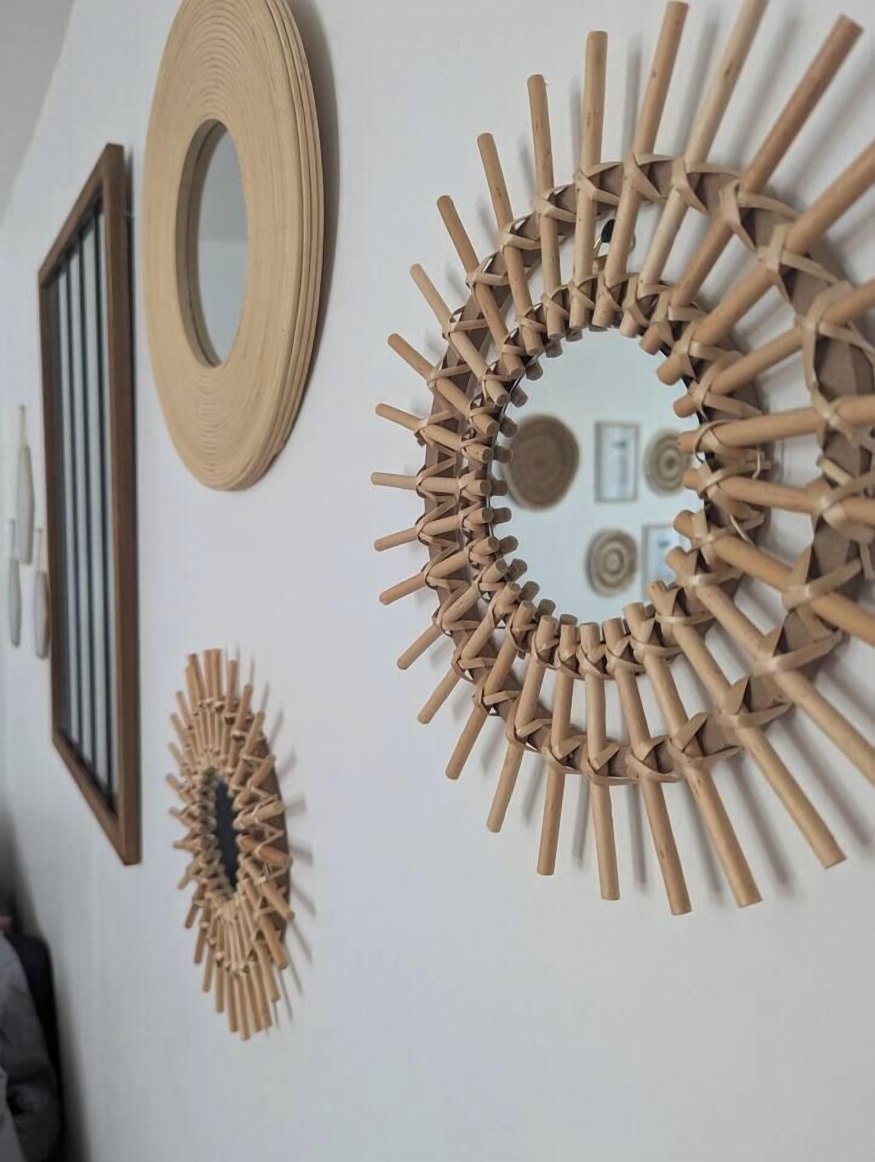 Un mur orné de trois éléments décoratifs en bois : un élément circulaire et deux éléments dont les motifs sont constitués de rayons en bois.