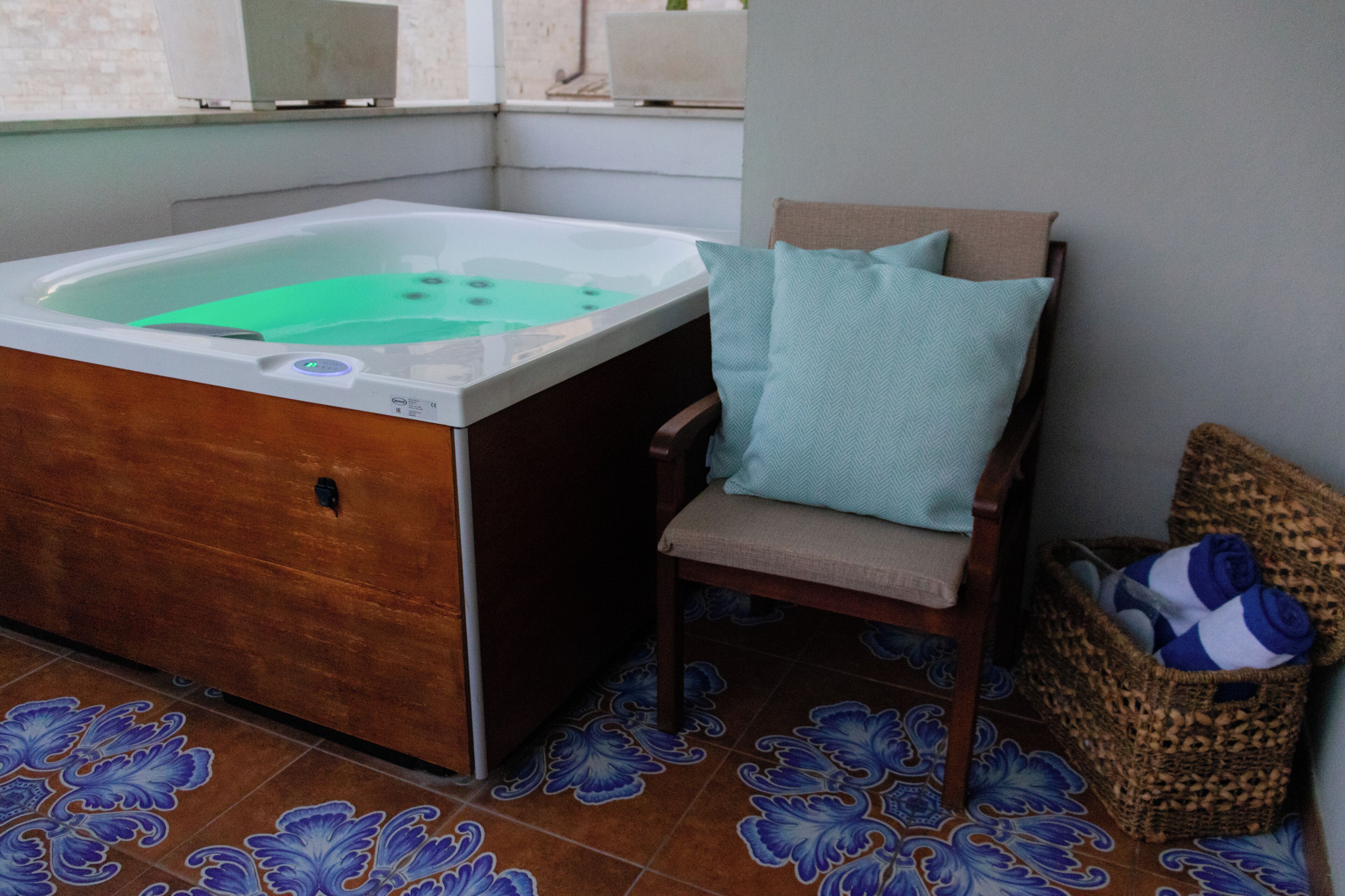 A bathroom with a bathtub, a chair, and a wicker basket.