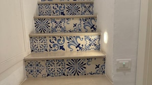 Uma escadaria com azulejos padronados em azul e branco.