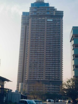 Un immeuble de grande hauteur, comportant de nombreux étages, vraisemblablement un immeuble d’habitation ou de bureaux.