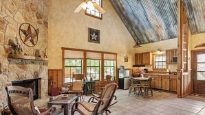 Un interior rústico con chimenea de piedra, muebles de madera y una zona de cocina.