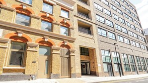A multi-story building with a brick facade, large windows, and a flat roof. - Roomspace Apartments -Caroline Street (London)