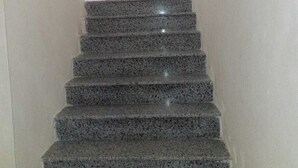A staircase with a handrail and a light-colored wall. - Brian's Rooms (Sarande)