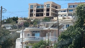 A multi-story residential building with balconies and a clear sky. - Brian's Rooms (Sarande)