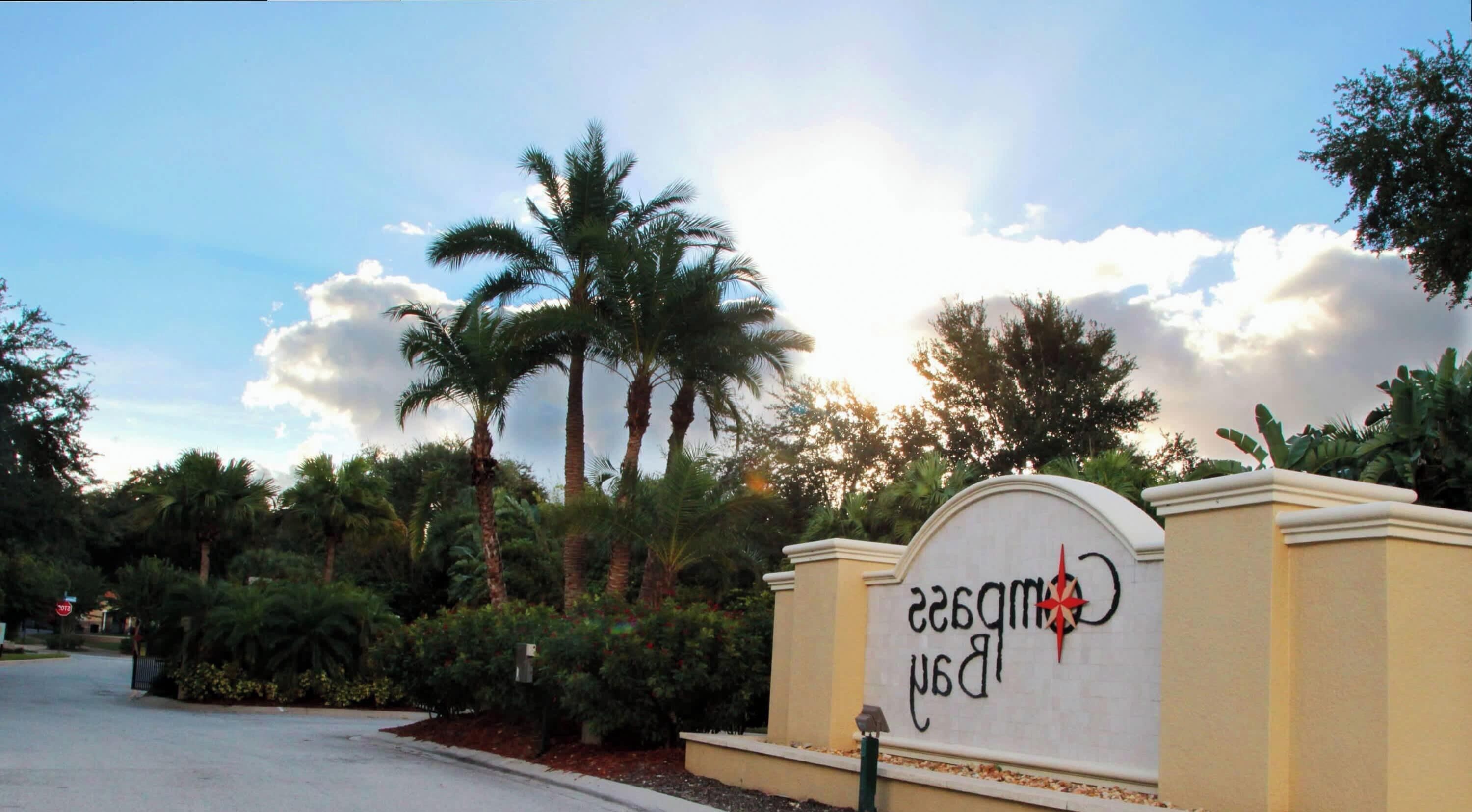 A sign with the text "Campsis Resort" surrounded by palm trees and greenery.