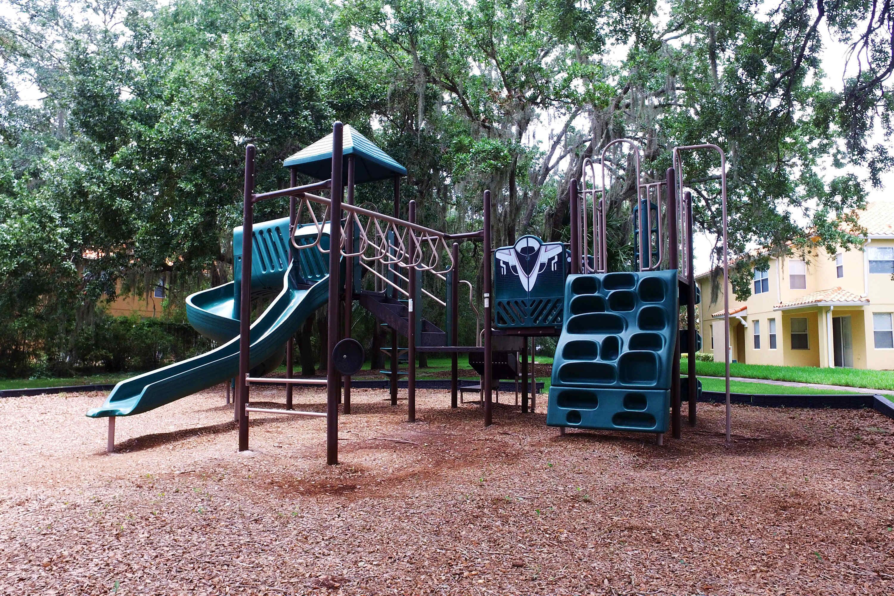 A playground with a slide, climbing structures, and a multi-level play area.