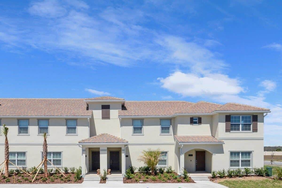 A two-story building with a symmetrical facade, multiple windows, and a central entrance with a covered porch.