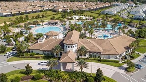 Un resort con varias piscinas, un edificio central con cúpula y un estacionamiento.