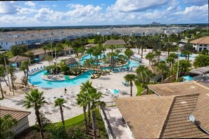 A resort with a large swimming pool, palm trees, and a view of the surrounding area. - Modern 2Bd Townhome Minutes to Disney w Waterpark (Davenport)