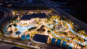 Eine Vogelperspektive zeigt ein Resort mit mehreren Schwimmbecken, einem großen Gebäude und einem Parkplatz.