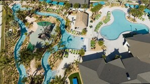 Ein Luftbild eines Resorts mit mehreren Schwimmbecken, Palmen und Liegebereichen.