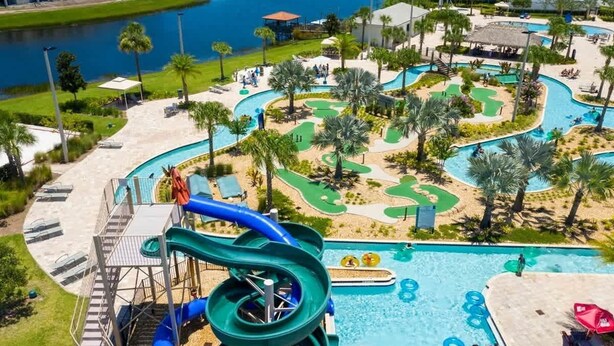 Een resort met een groot zwembad, waterglijbanen en een golfbaan.