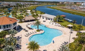 A resort with a large swimming pool, lounge areas, and a view of a lake. - Lake View Resort Condo w Lazy River Near Disney (Kissimmee)