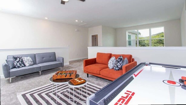 A modern living room with a pool table, two sofas, and a ceiling fan. - Family 5BD Spa Pool Game Loft Near Disney (Kissimmee)