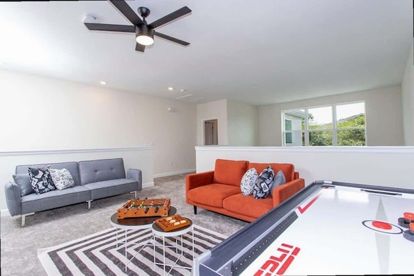 A modern living room with a pool table, two sofas, and a ceiling fan. - Family 5BD Spa Pool Game Loft Near Disney (Kissimmee)