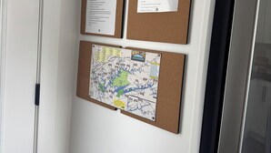 Mededelingenbord met berichten en een kaart, een deur met een handgreep, en een koelkast.