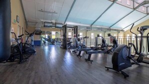 A gym with cardio machines, weight equipment, and a mirrored wall. - 2 Bedroom Mountain View Penthouse Century City (Cape Town)