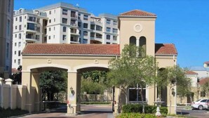A gated entrance with a beige building and a tower with arched windows. - 2 Bedroom Mountain View Penthouse Century City (Cape Town)